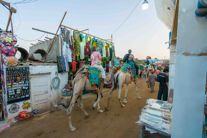 Tourists on camels crowding the narrow streets of the Nubian Village in Aswan
